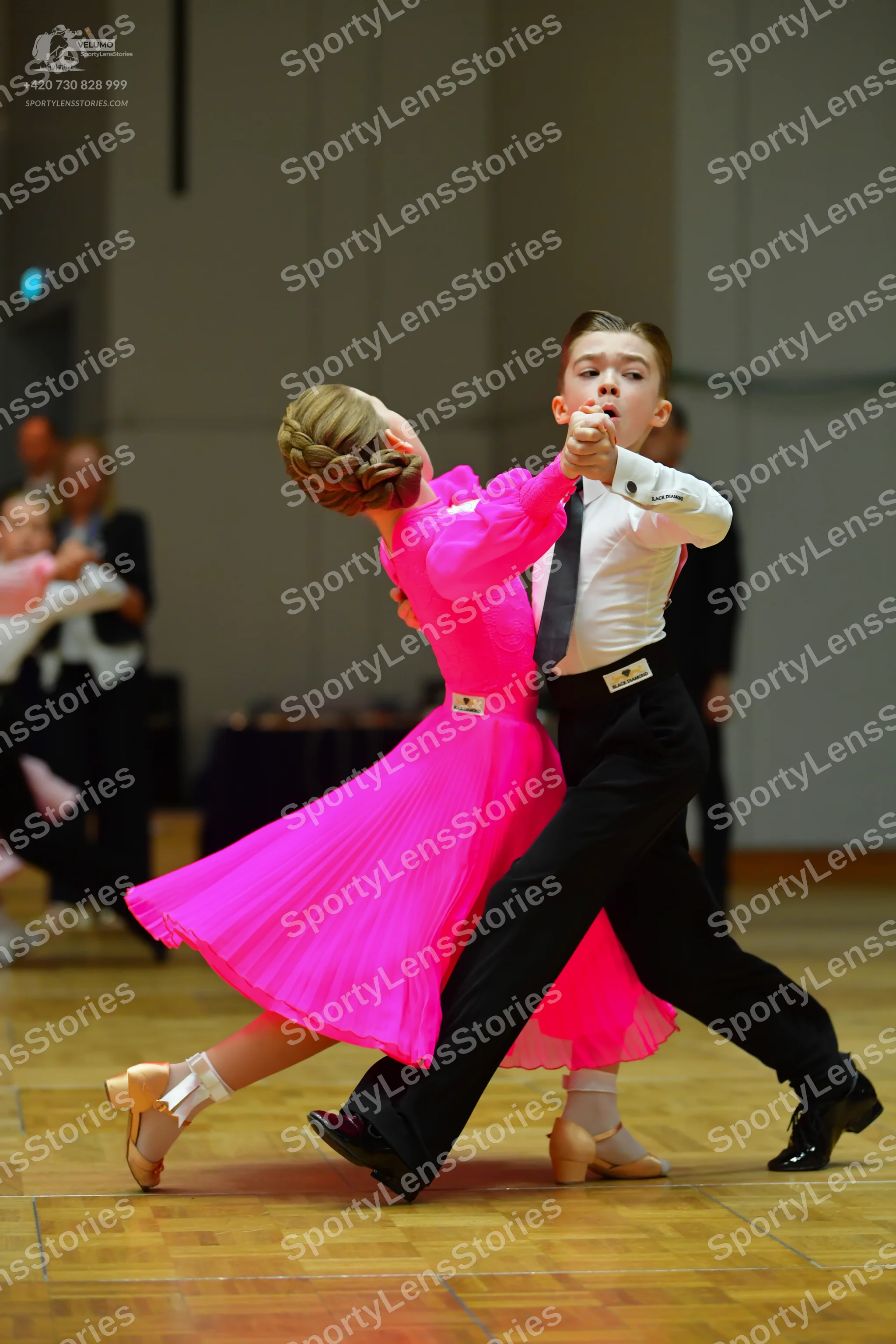 Dancesport competitor: Female dancer: bright pink long-sleeved ballroom dress with a full flowing skirt