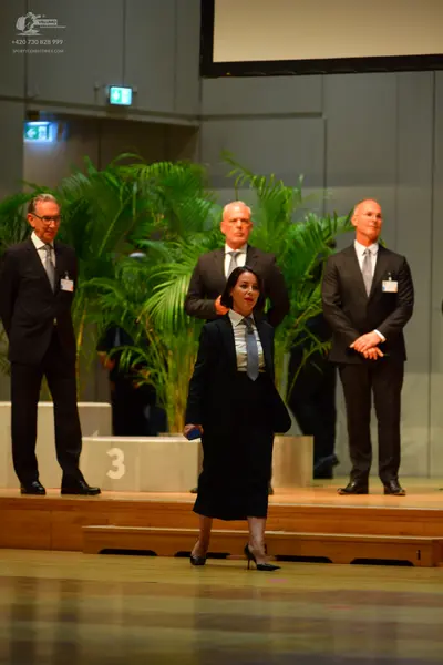 Dancesport competitor: No dancers are visible in the image; only officials in suits are present