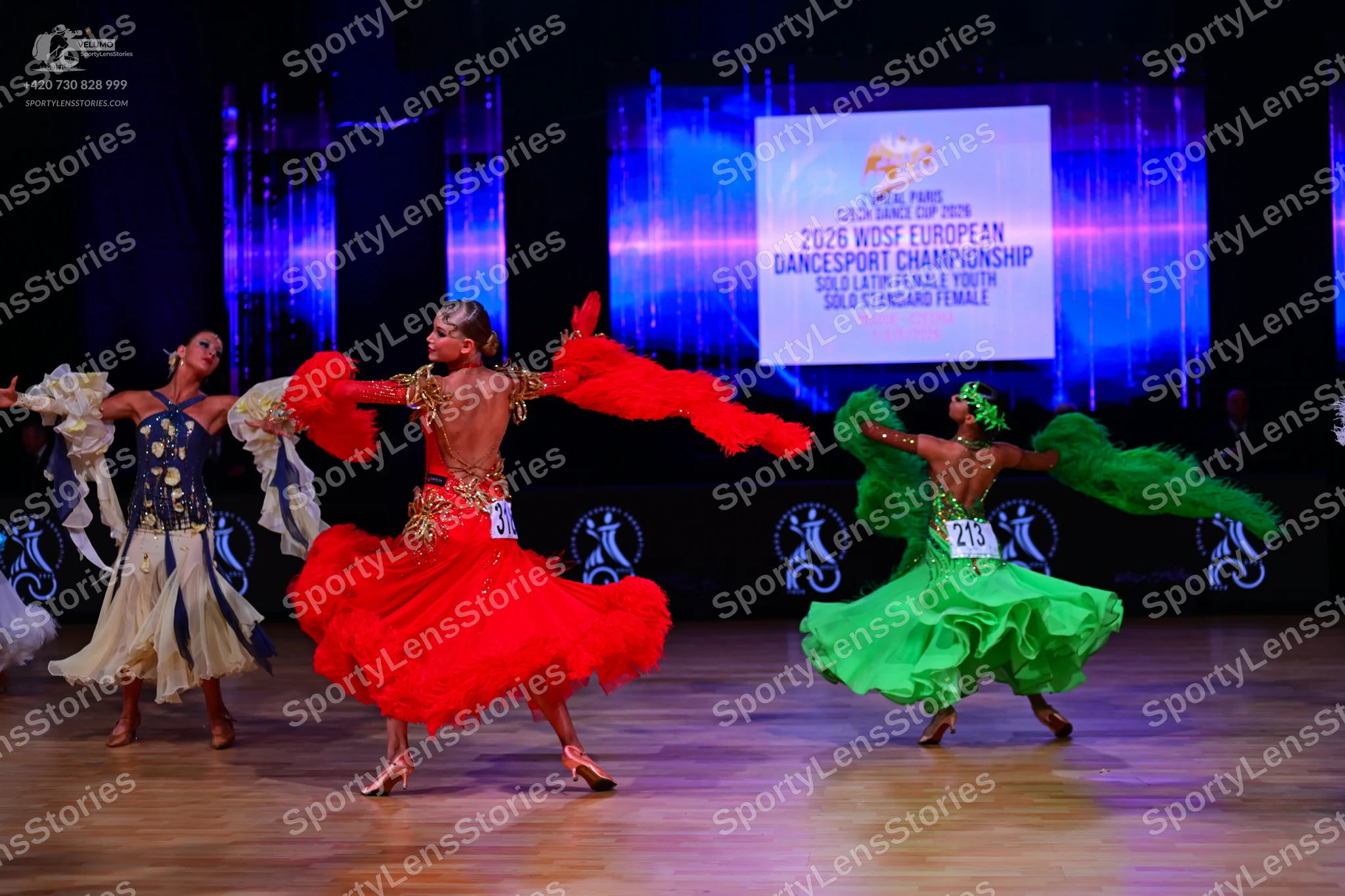 Dancesport competitor: First dancer: white Latin dress with blue and gold sequined bodice and a flowing