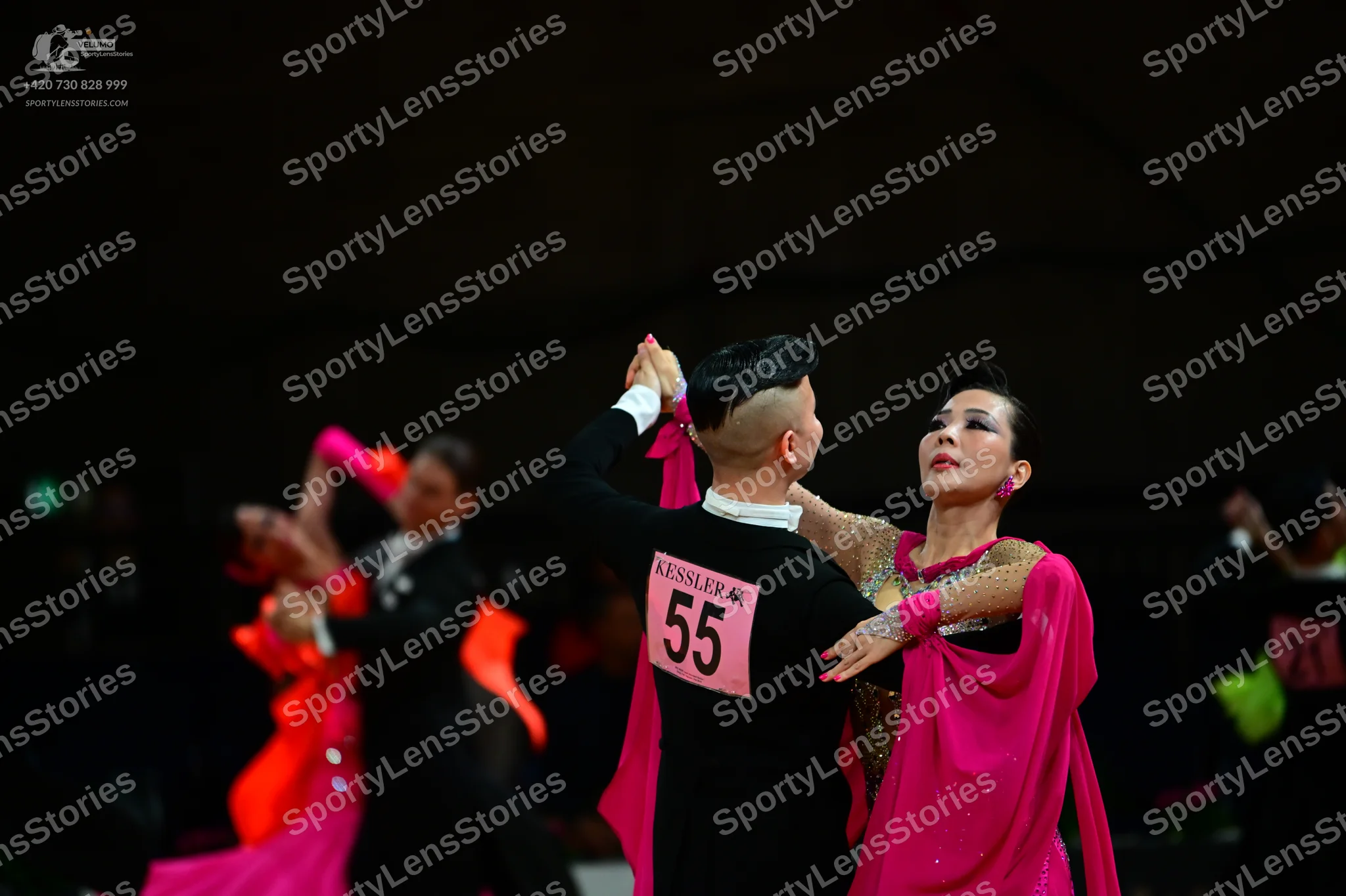 Dancesport competitor #55, #23: Male dancer (foreground): black long-sleeved top