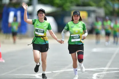 Marathon runner #5351, #5237: Runner 1: green jersey, black shorts, black socks, black shoes, black cap, glass