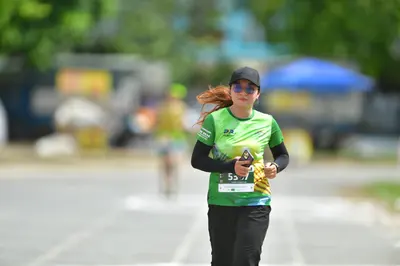 Marathon runner #557: Runner 1: green and yellow jersey, black long sleeves, black leggings, black cap