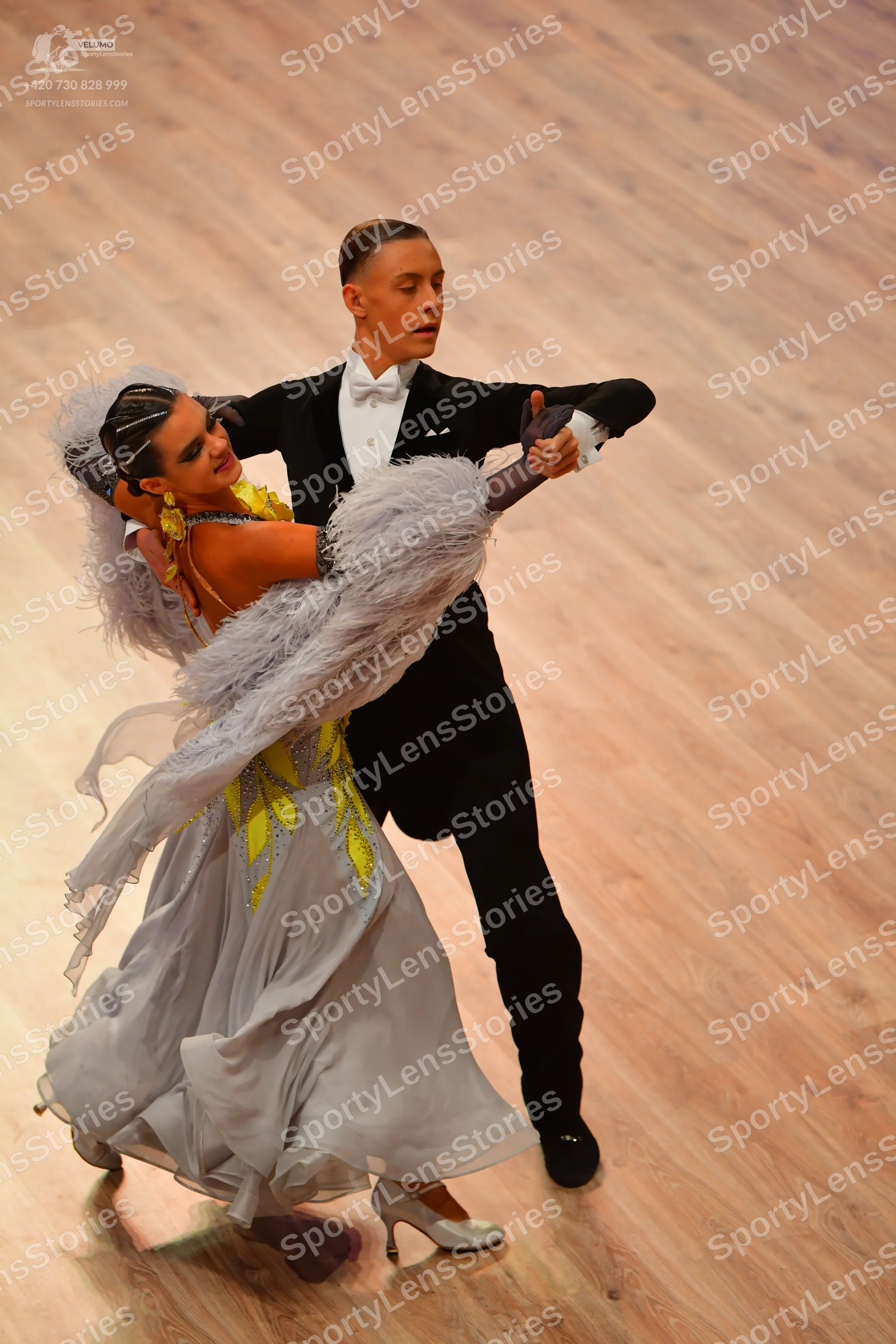 Dancesport competitor: Male dancer: black tuxedo with a white shirt and white bow tie