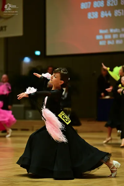 Dancesport competitor: ** Black latin dress with white lace inserts on the sleeves and bodice