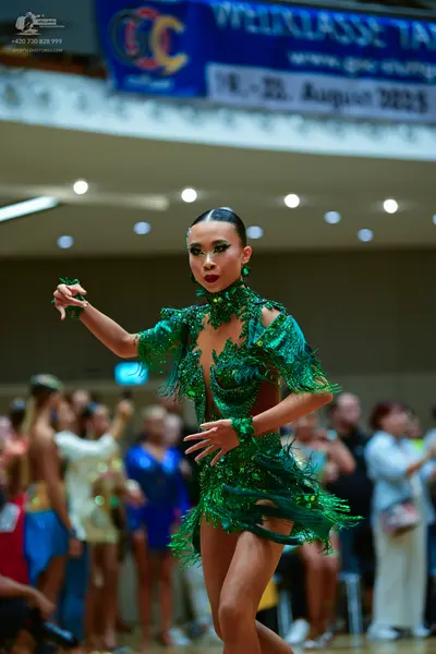 Dancesport competitor: Main female dancer: emerald green latin dance dress with sequins and long green 
