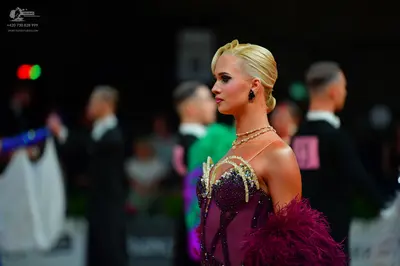 Dancesport competitor: Female dancer: burgundy Latin dress with a gold and silver embellished bodice an