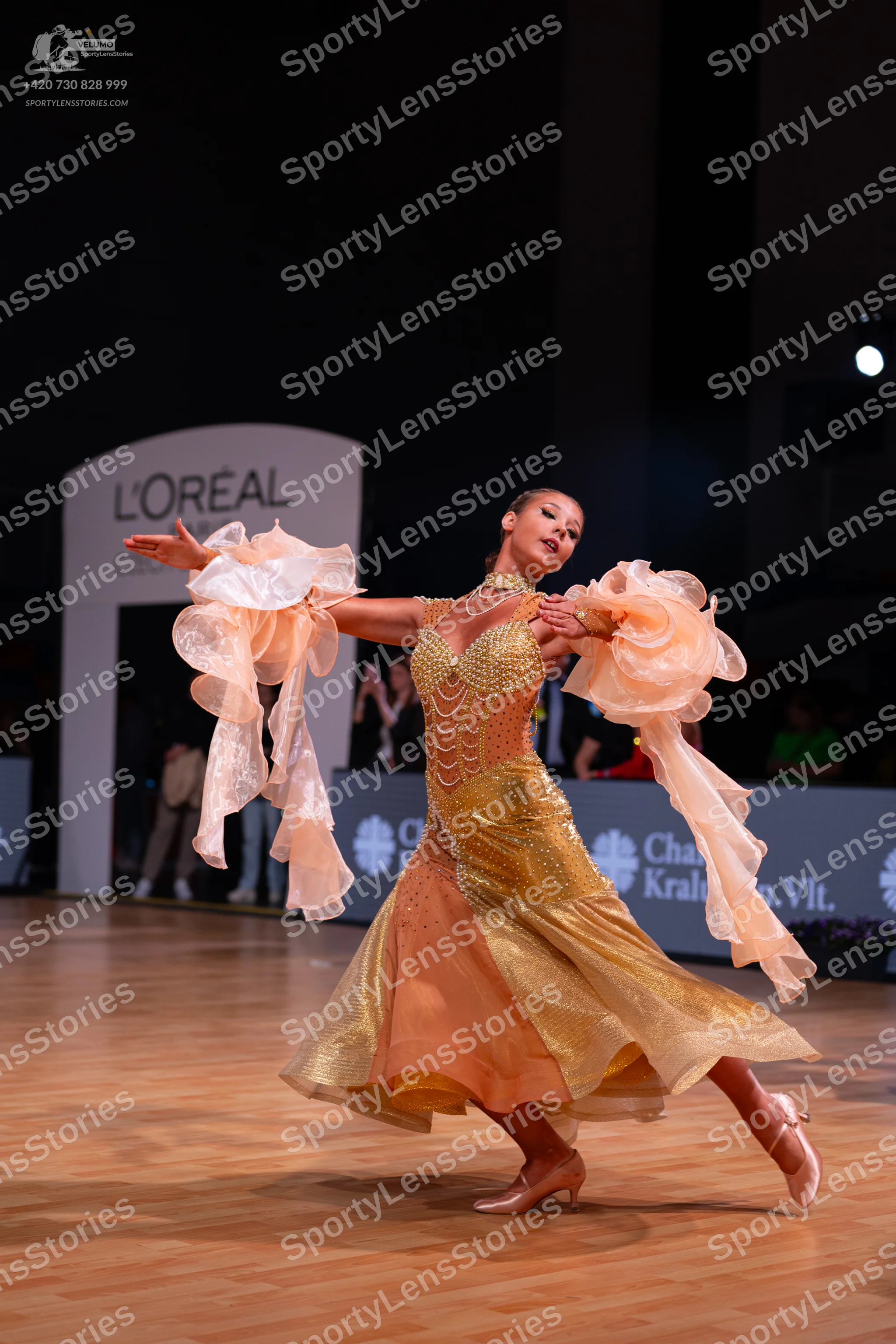 Dancesport competitor: Female dancer: champagne-colored ballroom dress with a sequined bodice and large