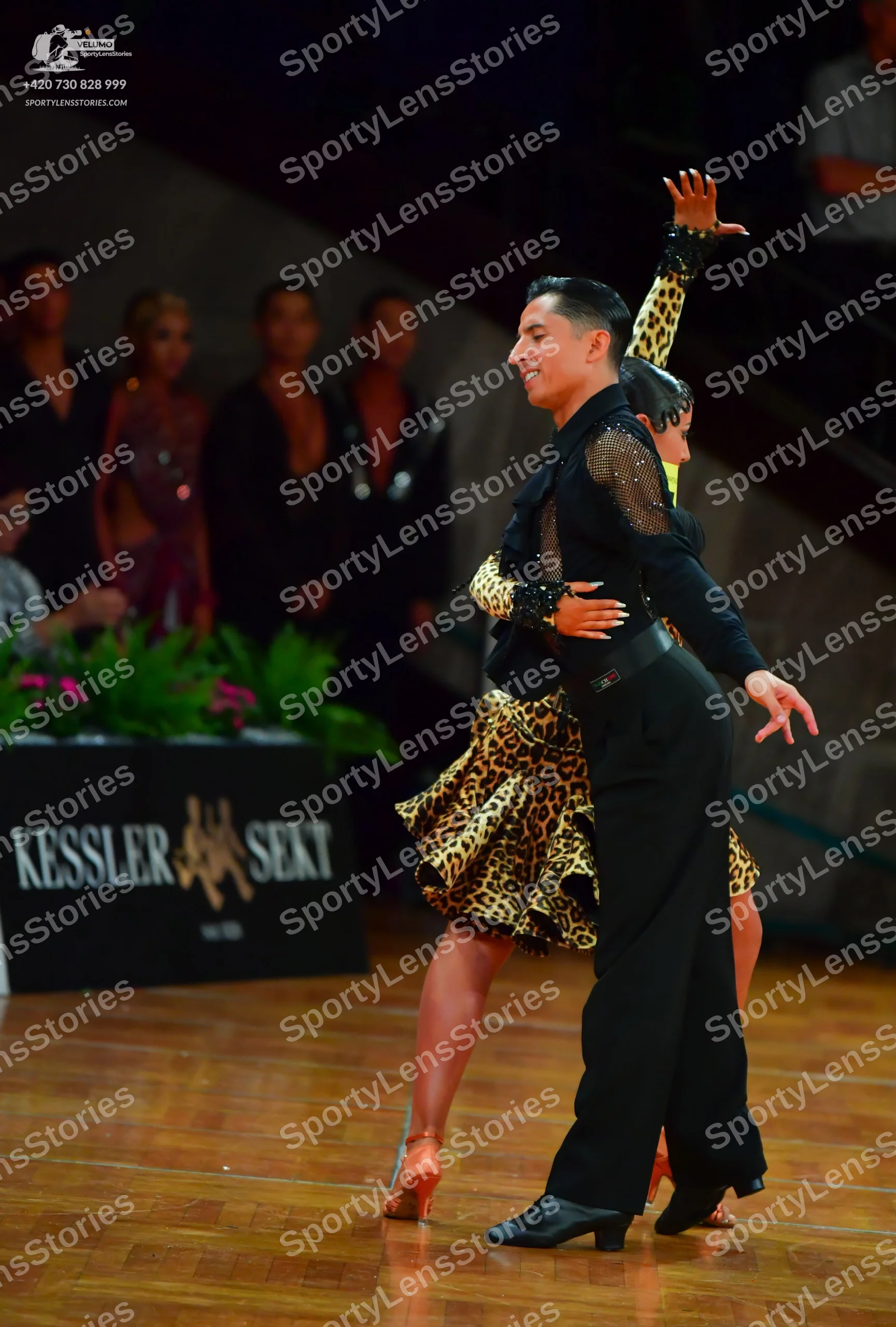 Dancesport competitor: Male dancer: black long-sleeved shirt with sheer mesh panels on the arms and bla