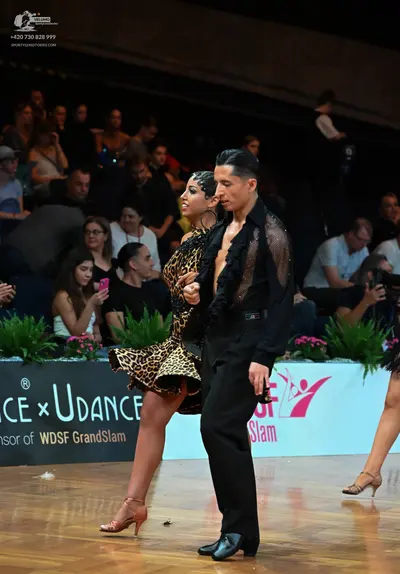 Dancesport competitor: Male dancer: black shirt with sheer, ruffled texture on the upper part and black