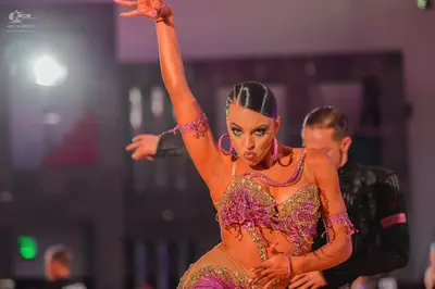 Dancesport competitor: Male dancer: black suit jacket with a pink/magenta design on the sleeve