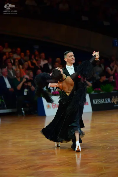 Dancesport competitor: Male dancer: black suit with a white shirt and white bow tie
