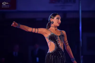 Dancesport competitor: Female dancer: black Latin dress with silver rhinestone embellishments, featurin