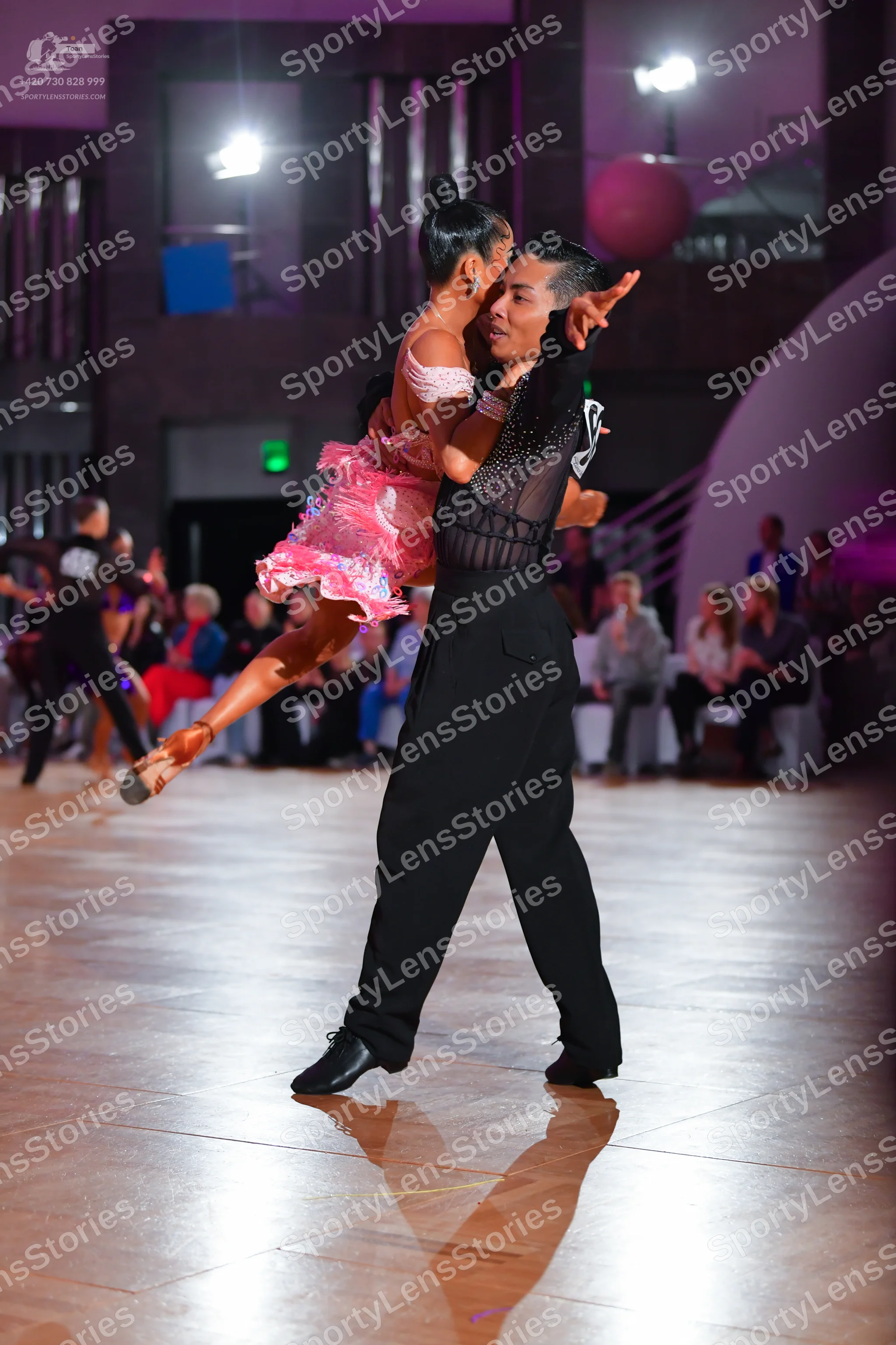 Dancesport competitor: Male dancer: black trousers and a black sleeveless top with a sheer mesh panel o