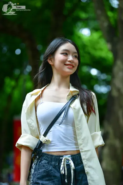 Dancesport competitor: The person is wearing a white tank top, an unbuttoned cream-colored long-sleeve 