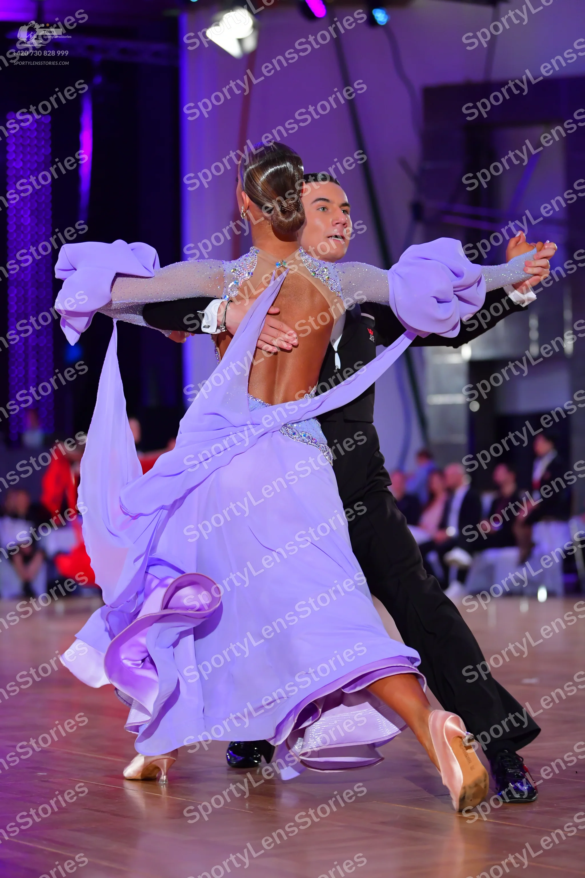 Dancesport competitor: Female dancer: long, flowing lavender dress with a voluminous, ruffled skirt and