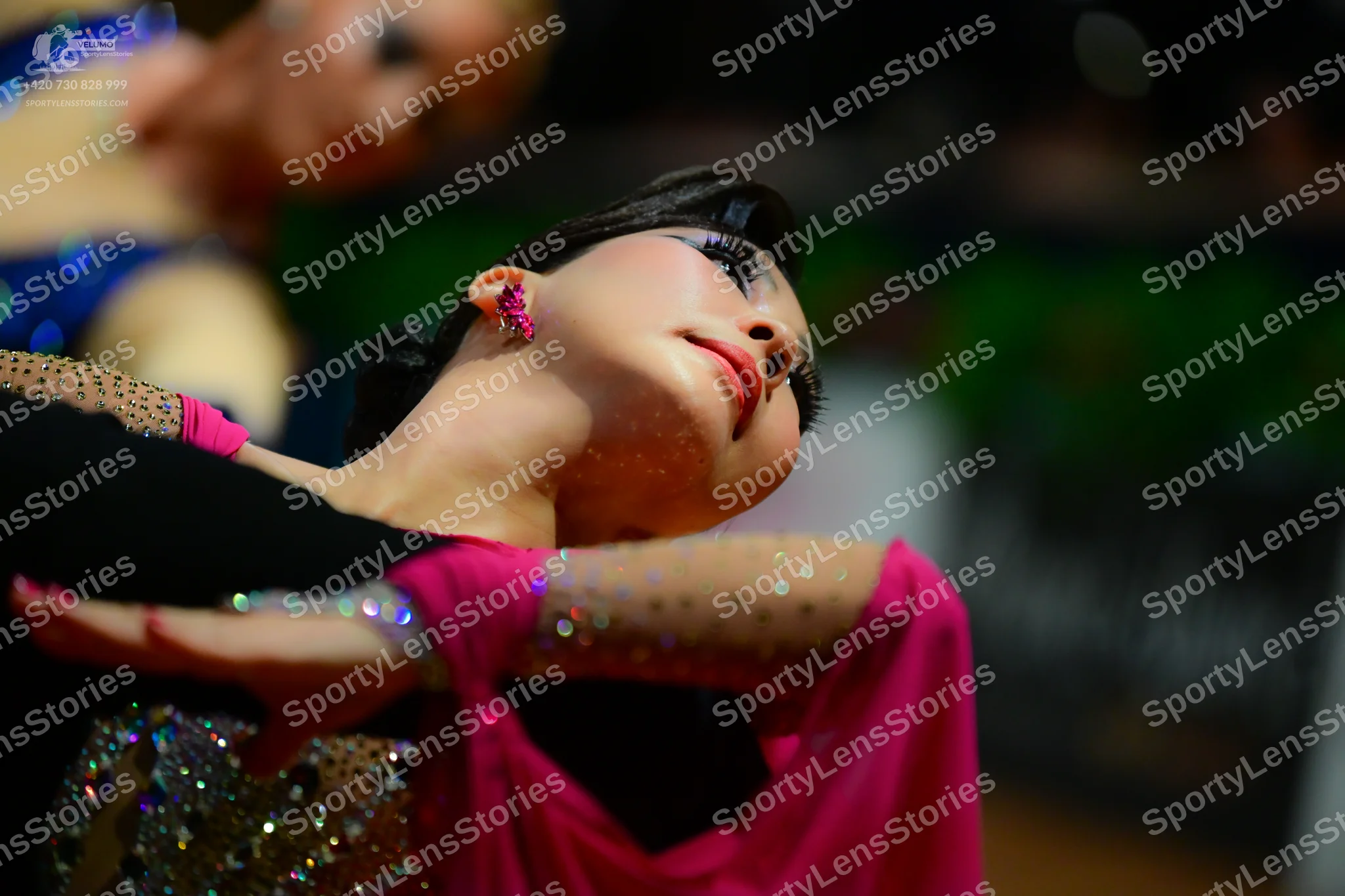 Dancesport competitor: Dancer in background: blue top