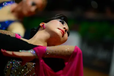 Dancesport competitor: Dancer in background: blue top
