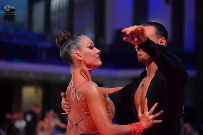 Dancesport competitor: Female dancer: tan-colored Latin dress with intricate sequin and bead embellishm