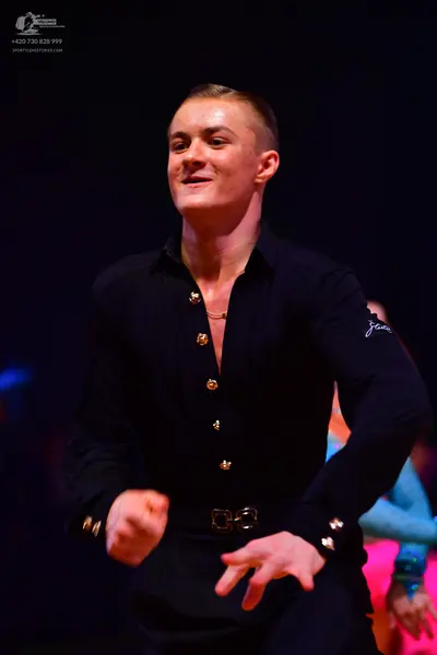 Dancesport competitor: Male dancer: black long-sleeved shirt with gold buttons and black trousers with 