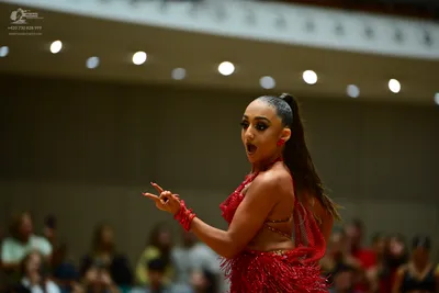 Dancesport competitor: Female dancer: red Latin dress with fringe and embellishments