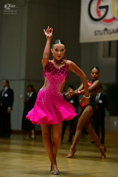 Dancesport competitor: Female dancer: pink sequined Latin dress with cutouts