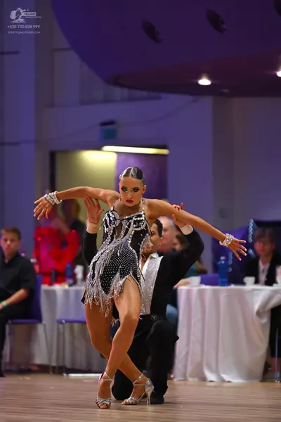 Dancesport competitor: Female dancer: black Latin dress with silver sequins and silver fringe, paired w