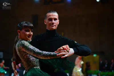 Dancesport competitor: Female dancer: green and gold sequined long-sleeved top with a green fringe skir