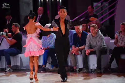 Dancesport competitor: Female dancer: pink, multi-layered, ruffled Latin dress with shimmering fabric
