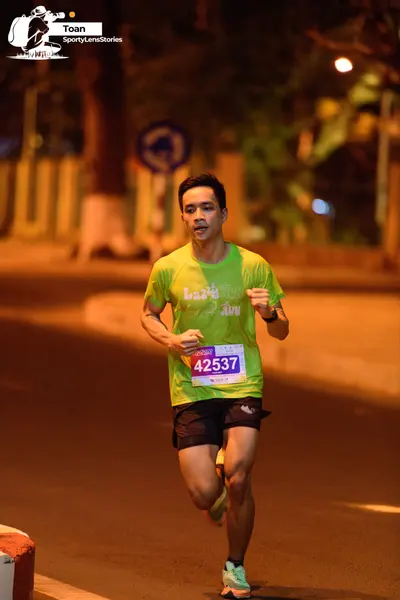 Marathon runner #42537: Runner 1: lime green jersey, black shorts, light blue shoes