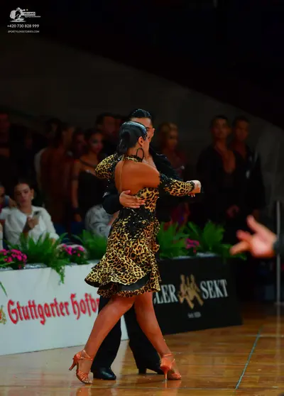 Dancesport competitor: Female dancer: leopard print latin dress with long sleeves and black embellishme