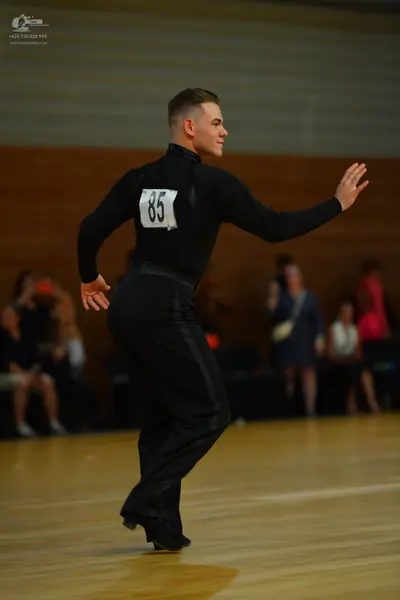 Dancesport competitor: Male dancer: black long-sleeved top and black trousers