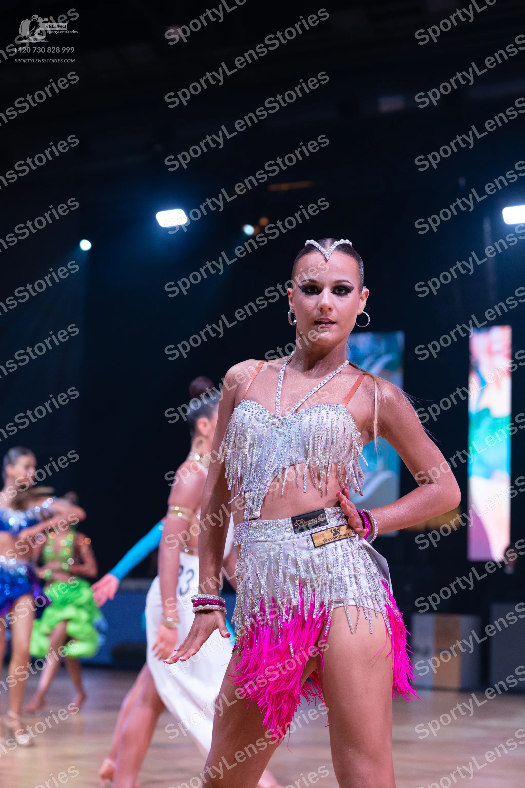 Dancesport competitor: Female dancer: silver sequin latin dress with pink fringe at the hem