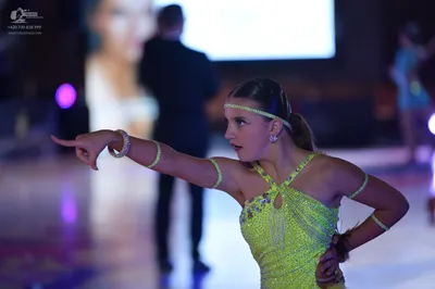 Dancesport competitor: Female dancer: lime green sequined latin dress with cutout details and matching 