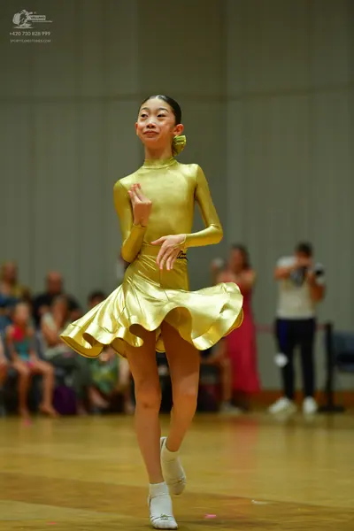 Dancesport competitor: Female dancer: gold-colored, long-sleeved, high-necked dress with a short, flare