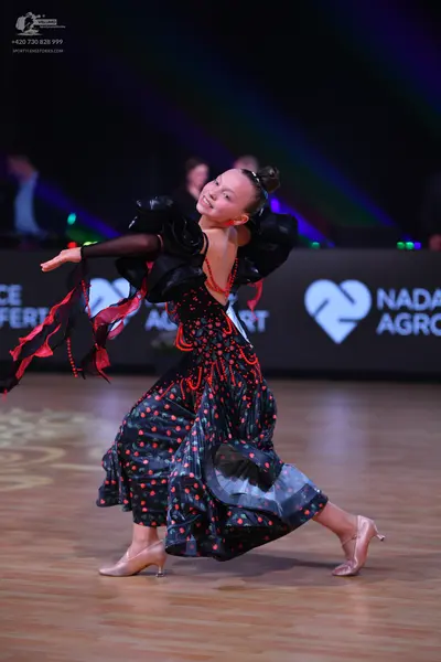 Dancesport competitor: Female dancer: black ballroom dress with red polka dots, red beaded embellishmen