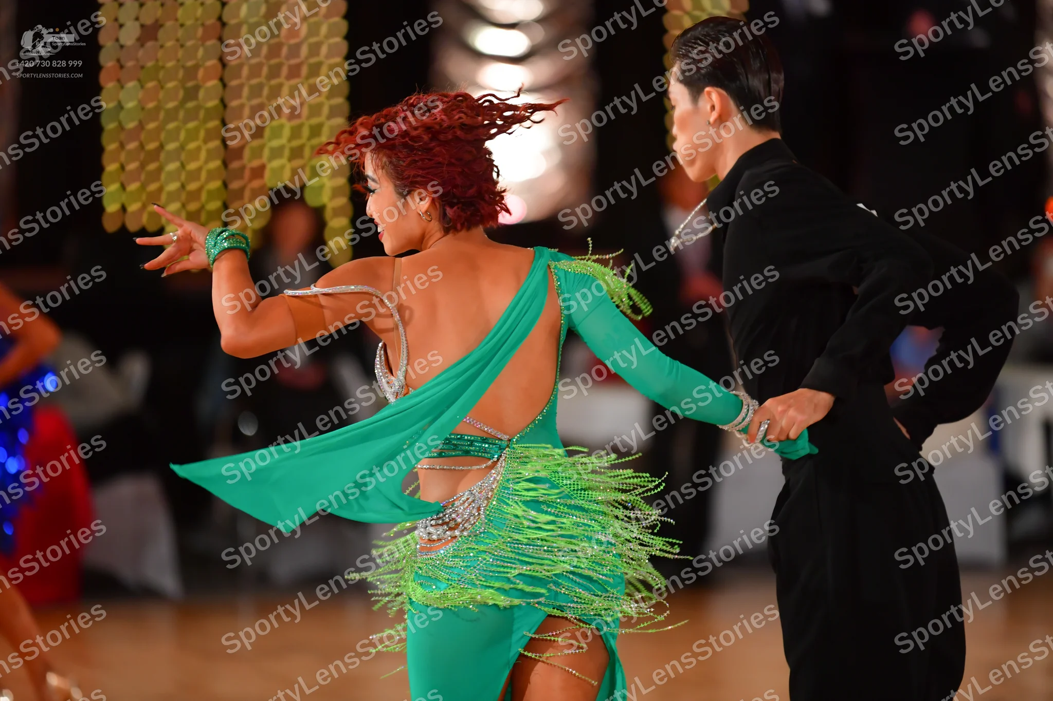 Dancesport competitor: Female dancer: teal latin dress with fringe, a long sleeve, and sequin embellish