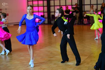 Dancesport competitor: Female dancer: blue long-sleeved latin dress with a flared skirt