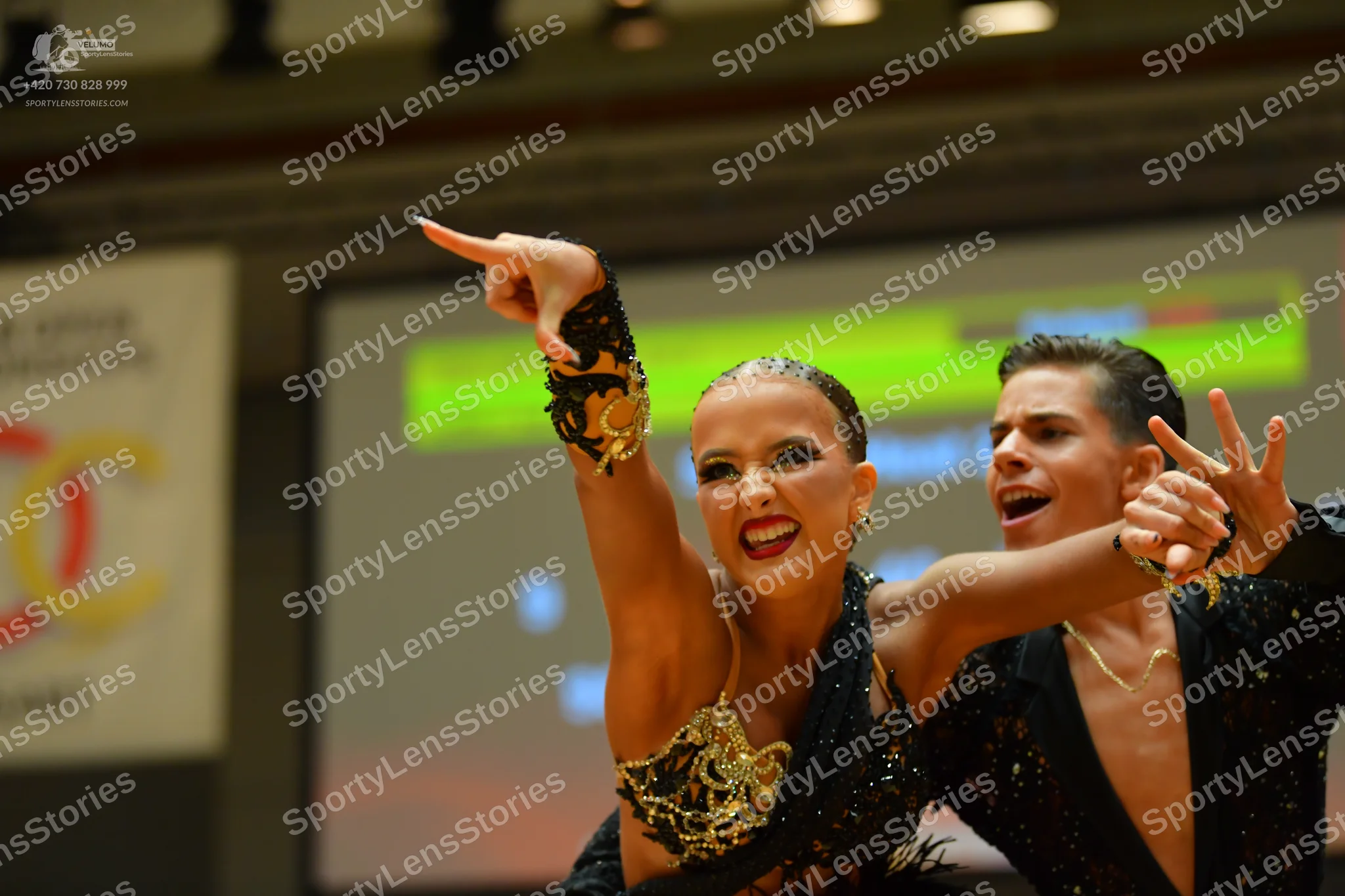 Dancesport competitor: Female dancer: black latin costume featuring elaborate gold sequined or embroide