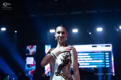Dancesport competitor: Female dancer: white Latin dance costume with a large leopard print panel on the