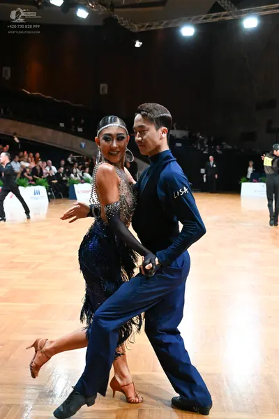 Dancesport competitor: Female dancer: navy blue sequined Latin dance dress with long matching gloves an