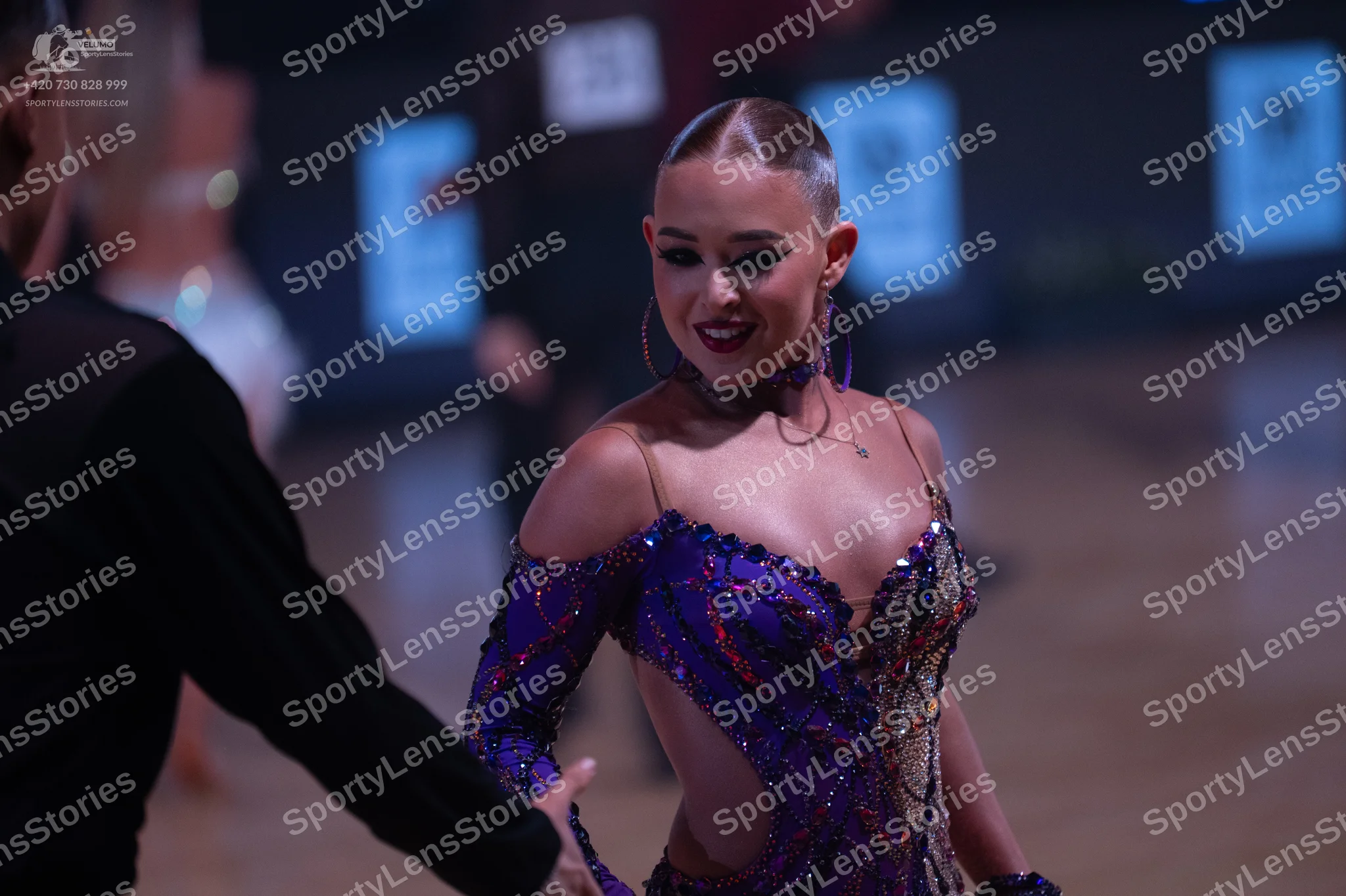 Dancesport competitor: Female dancer: purple Latin dance dress heavily embellished with sequins and rhi