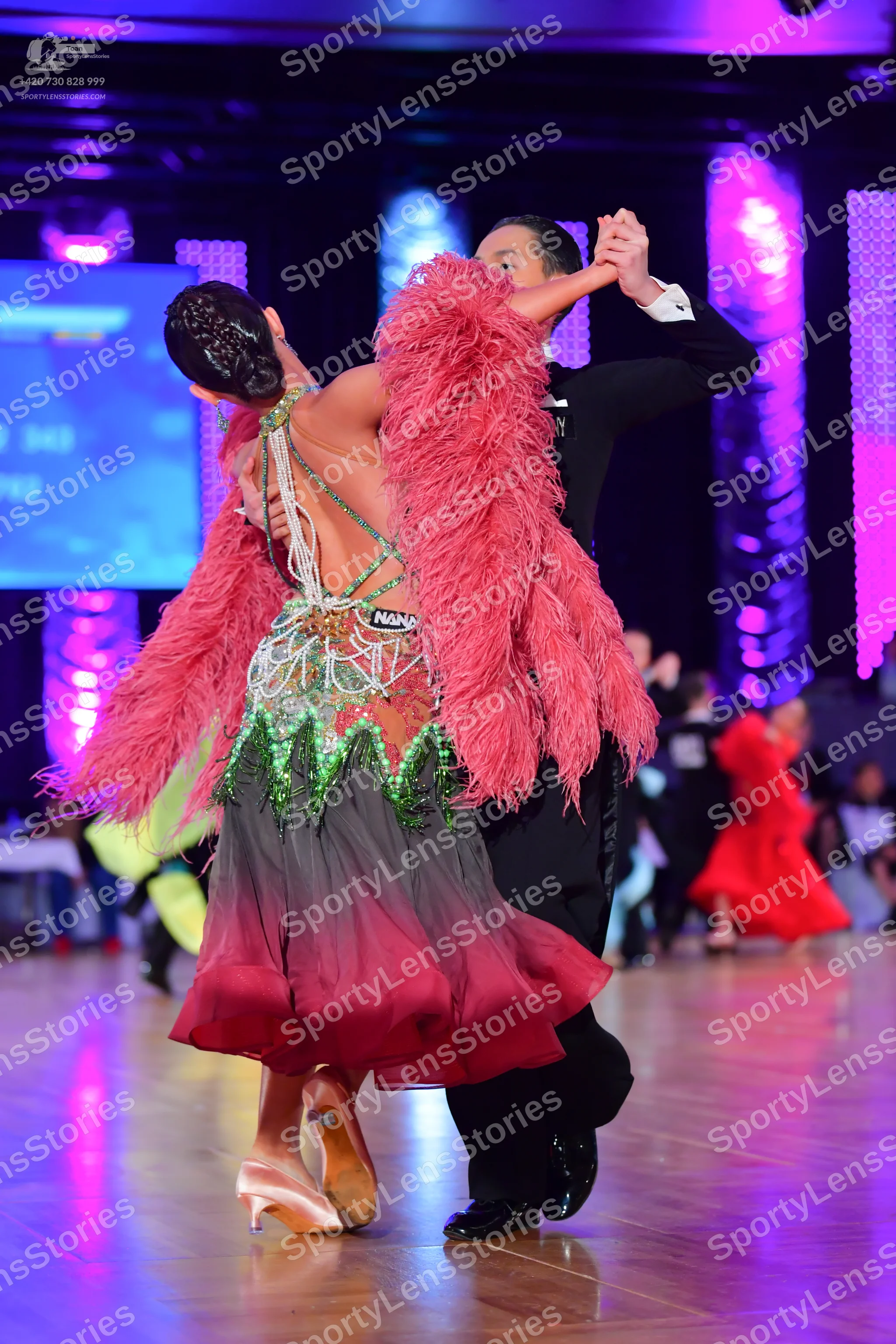 Dancesport competitor: Male dancer: black ballroom suit with a white shirt cuff visible