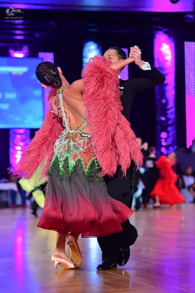 Dancesport competitor: Male dancer: black ballroom suit with a white shirt cuff visible
