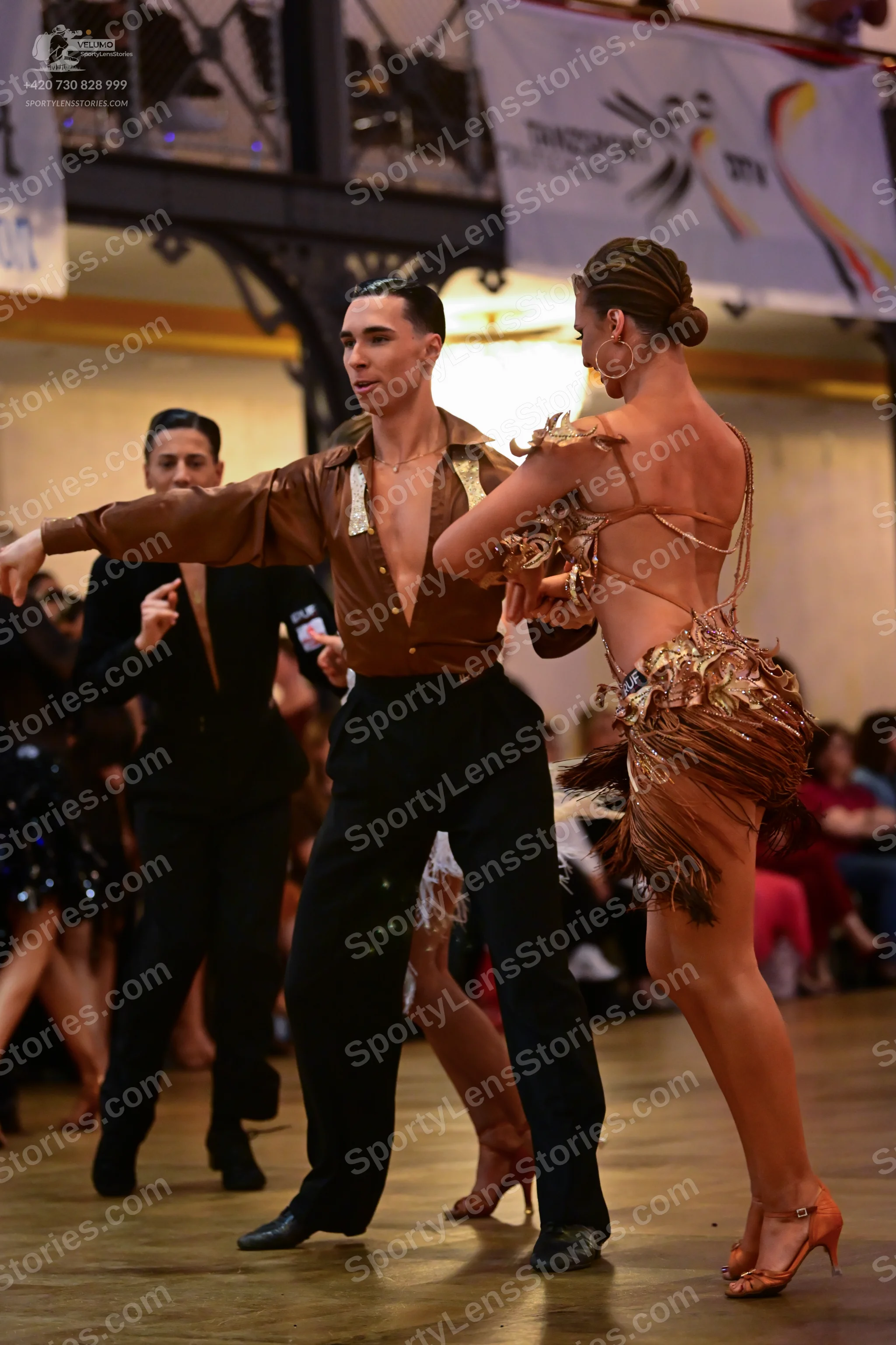 Dancesport competitor: Male dancer: bronze metallic long-sleeved shirt with a sequin strip and black tr