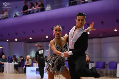 Dancesport competitor: Male dancer: black long-sleeved shirt with a large white satin or sequined front