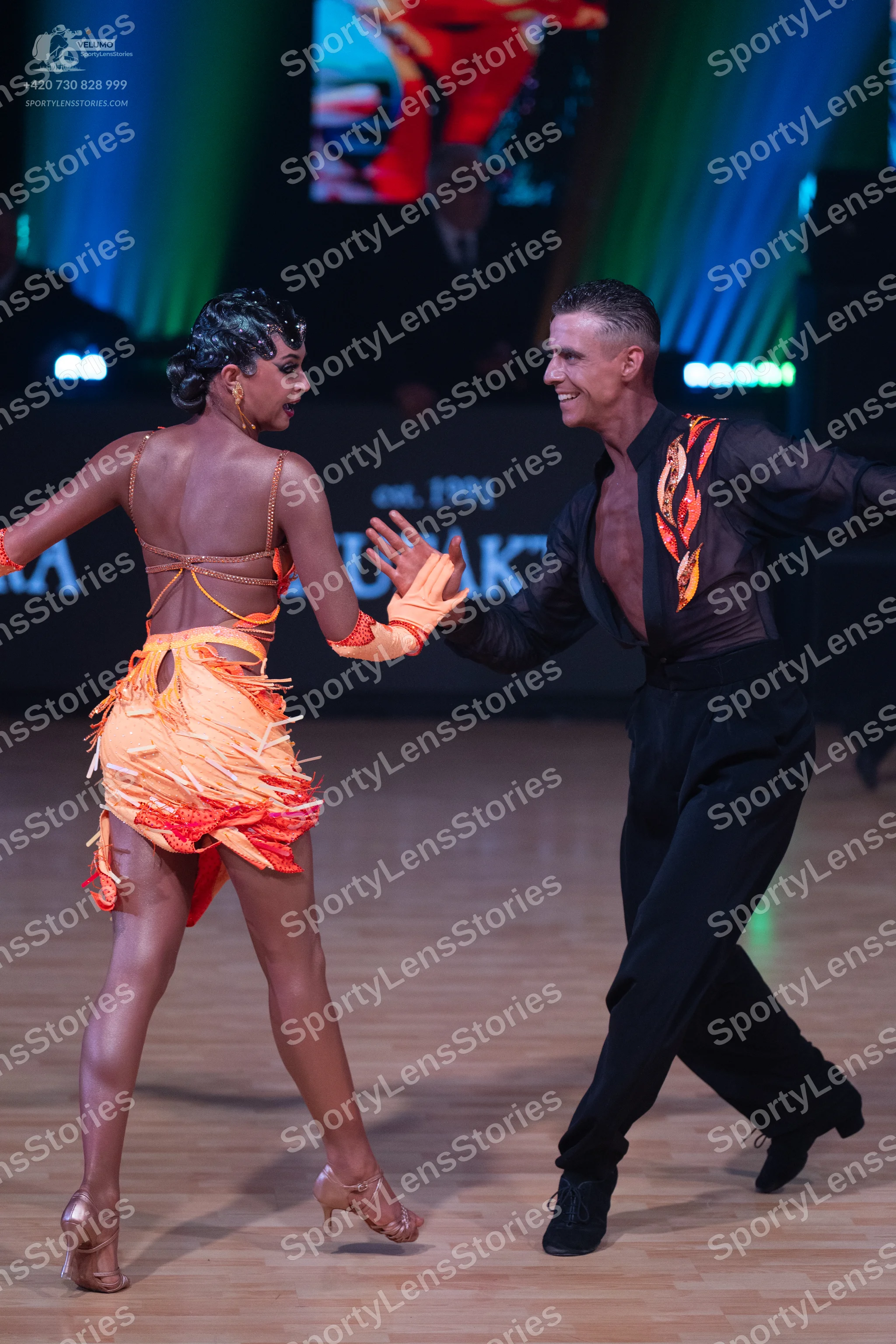 Dancesport competitor: Female dancer: orange and yellow gradient latin dress with fringe and cut-out ba