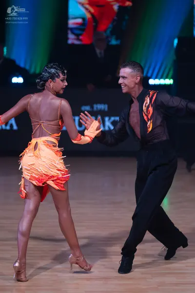 Dancesport competitor: Female dancer: orange and yellow gradient latin dress with fringe and cut-out ba