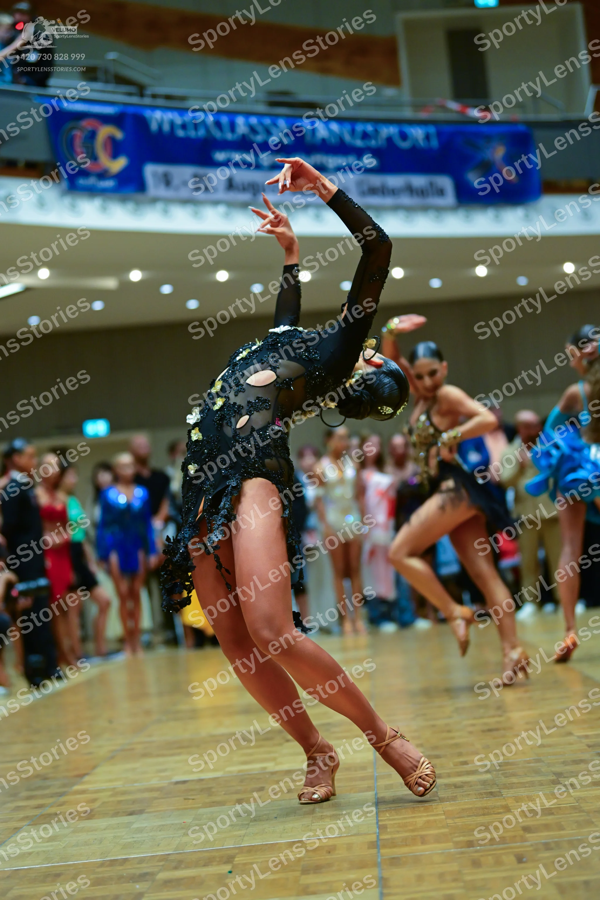 Dancesport competitor: Female dancer 1: black long-sleeved latin dress with cutouts and sequin embellis