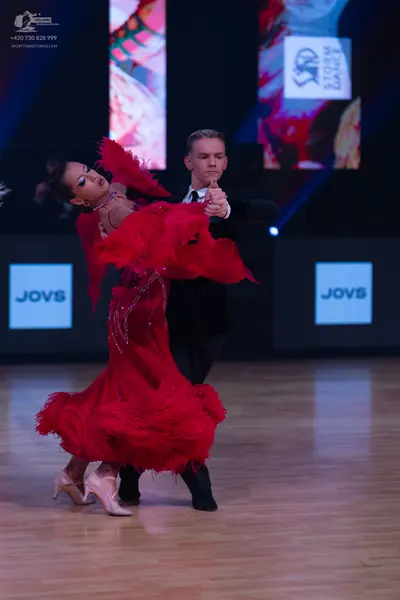 Dancesport competitor: Female dancer: red latin dress with feathers and sequins