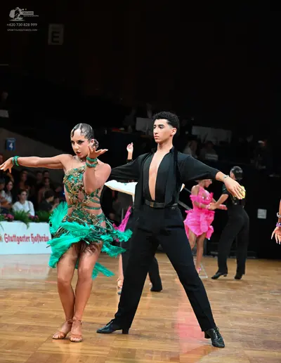 Dancesport competitor: Female dancer: green and gold sequined Latin dance dress with a bright green lay